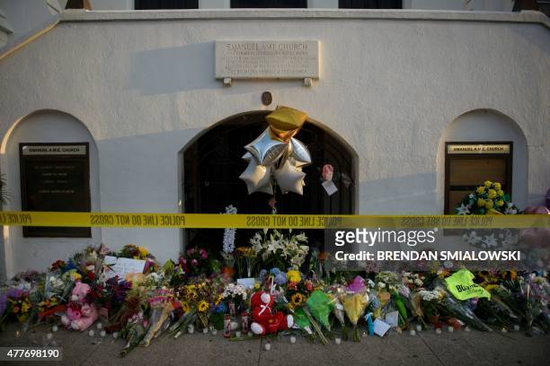 Morning view of a memorial outside the Emanuel AME Church June 19, 2015 in Charleston, South Carolina. US police arrested a white high school dropout...