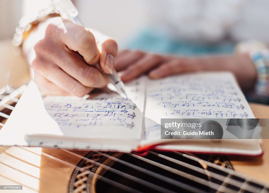 Woman writing down music notes
