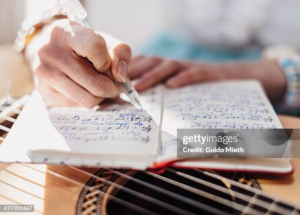 woman writing down music notes - writing music stock pictures, royalty-free photos & images