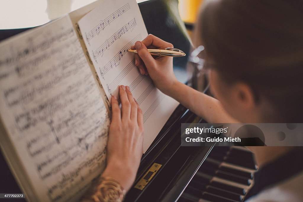 Woman writing down music notes