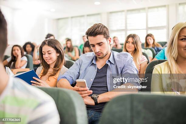 étudiant sms sur téléphone portable pendant un cours. - call conference photos et images de collection