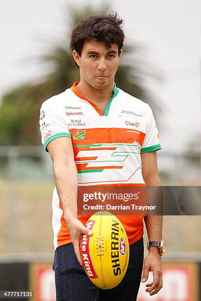 Force India driver Sergio Perez kicks an Australian football at Whitten Oval on March 11, 2014 in Melbourne, Australia.