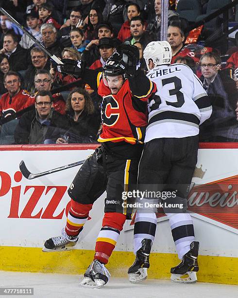 Ben Hanowski of the Calgary Flames collides with Willie Mitchell of the Los Angeles Kings during an NHL game at Scotiabank Saddledome on March 10,...