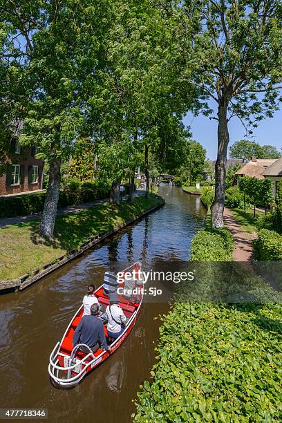 tourists in a boat on the canal in giethoorn - giethoorn stockfoto's en -beelden