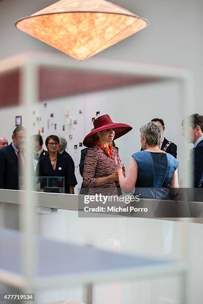 Queen Maxima of The Netherlands looks at a lamp by Wieki Somers and a Muller and van Seeveren designed shelves while opening the Design Derby...