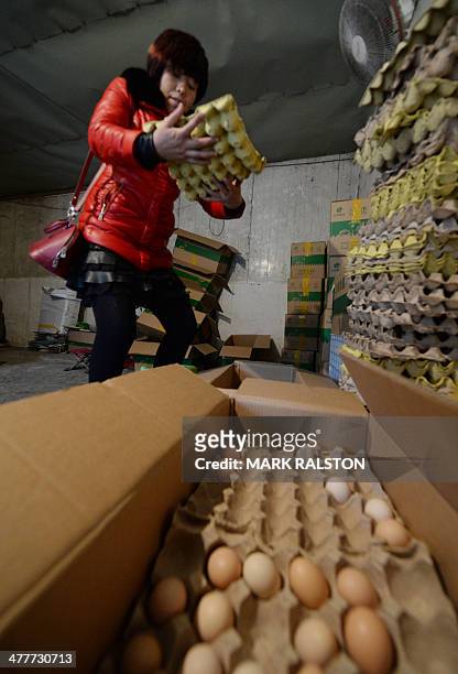 To go with China-health-flu-poultry,FOCUS by Bill Savadove This photo taken on February 17, 2014 shows a woman with organic eggs that she is banned...
