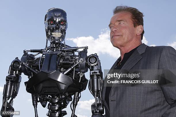 Actor and former governor of California Arnold Schwarzenegger poses with the Terminator animatronics robot during a photo call for the film...