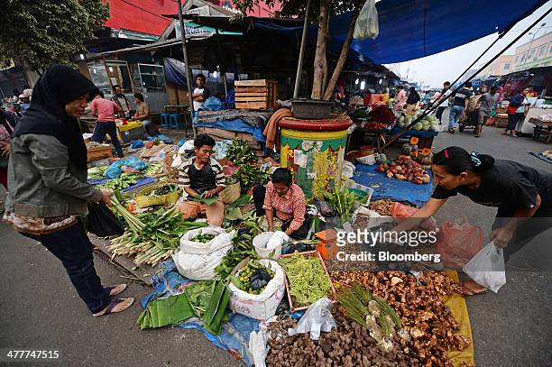 Customers shop for herbs and spices at a market in Pekanbaru, Riau Province, Indonesia on Friday, March 7, 2014. Indonesian central bank Governor...