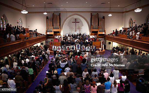 Photographs of the nine victims killed at the Emanuel African Methodist Episcopal Church in Charleston, South Carolina are held up by congregants...