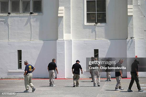 Crime scene investigators comb the parking lot on the back side of the historic Emanuel African Methodist Episcopal Church where nine people were...