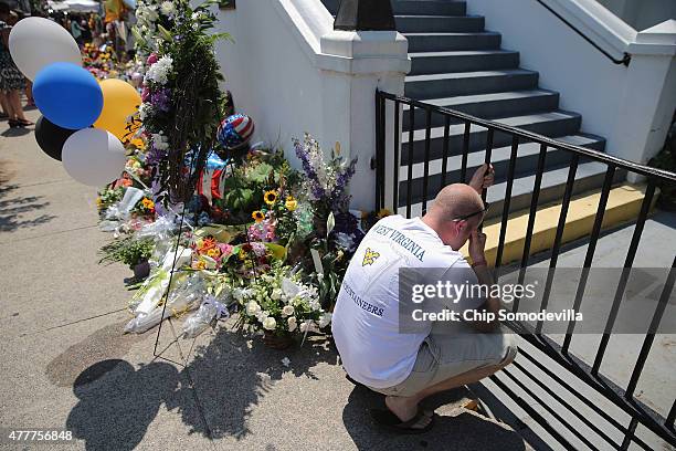Mourners continue to pray outside the historic Emanuel African Methodist Episcopal Church where nine people were shot to death this week June 19,...
