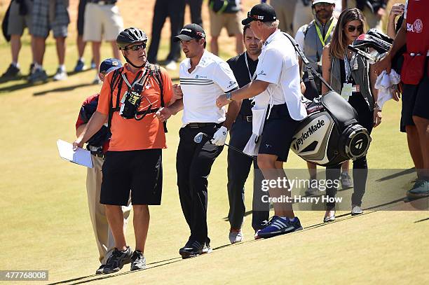 Jason Day of Australia stands up after falling on the ninth green due to dizziness during the second round of the 115th U.S. Open Championship at...