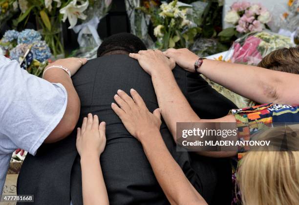 People pray outside Emanuel AME Church in Charleston, South Carolina, on June 19, 2015. Police captured the white suspect in a gun massacre at one of...