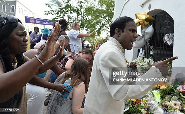 People pray outside Emanuel AME Church in Charleston, South Carolina, on June 19, 2015. Police captured the white suspect in a gun massacre at one of...