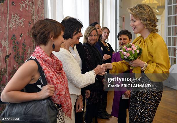 Queen Mathilde of Belgium shakes hands with one of the leading women from various sectors in the Antwerp province, on March 11 in Hingene. AFP PHOTO...