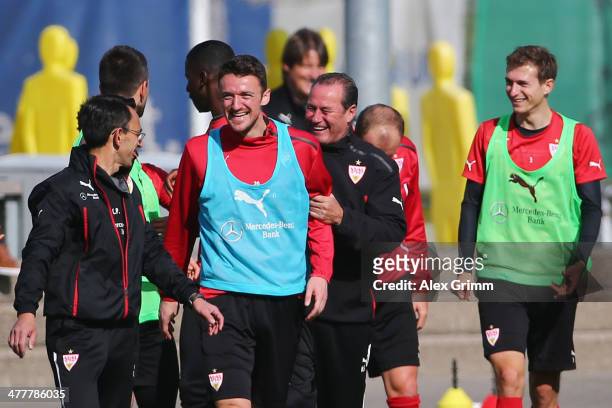 Head coach Huub Stevens laughs with Christian Gentner during a VfB Stuttgart training session at the club's training ground on March 11, 2014 in...