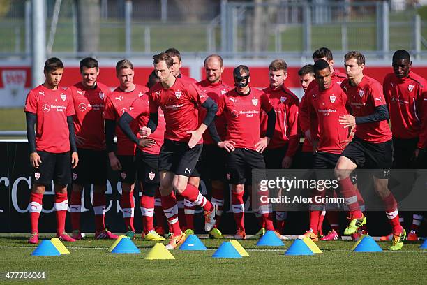 Team mates watch Georg Niedermeier and Daniel Schwaab exercise during a VfB Stuttgart training session at the club's training ground on March 11,...