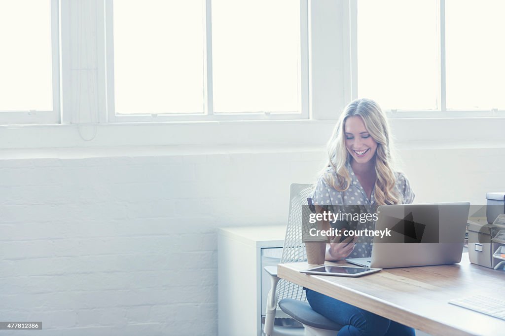 Attraktive Frau, die arbeitet auf einem laptop-computer.