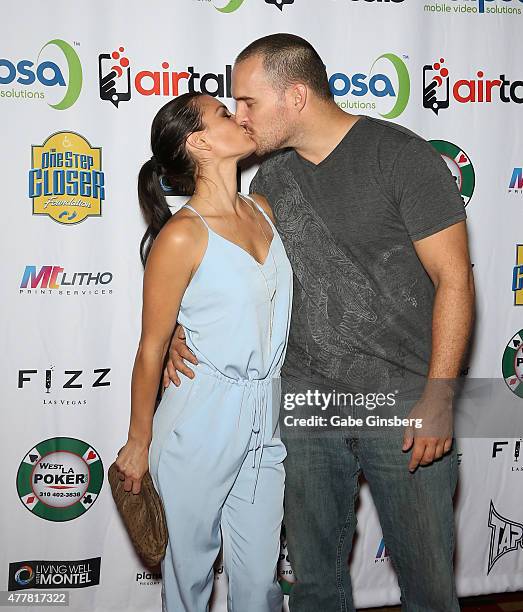 Actress Erin O'Brien kisses actor/stuntman Erik Aude as they attend the Raising the Stakes for Cerebral Palsy Celebrity Poker Tournament at Planet...