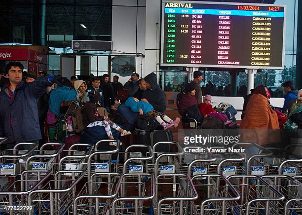 Tourists return to their hotels from the airport after all the flights were cancelled by the authorities following a heavy snowfall on March 11 in...