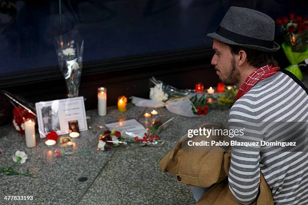 Man looks at candles, letters and flowers placed for the victims of Madrid train bombings outside a memorial monument at Atocha railway station...