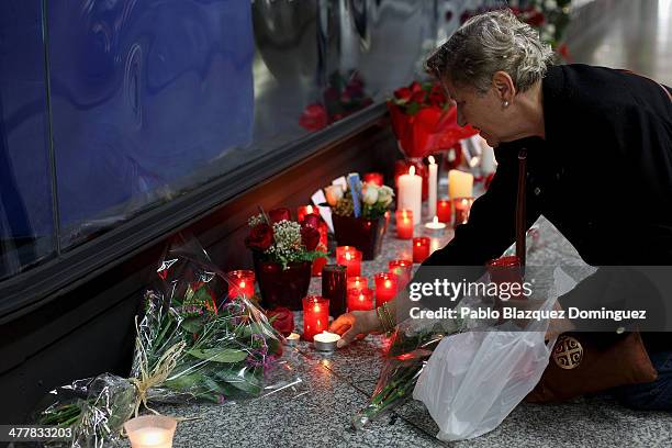 Woman places candles and flowers for the victims of Madrid train bombings outside a memorial monument at Atocha railway station during the 10th...