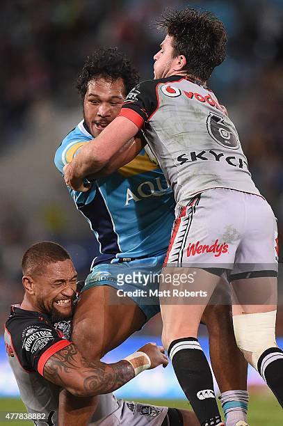 Agnatius Paasi of the Titans is tackled during the round 15 NRL match between the Gold Coast Titans and the New Zealand Warriors at Cbus Super...