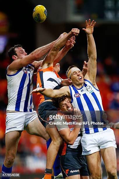 Todd Goldstein and Drew Petrie of the Kangaroos compete for the ball against Aidan Corr of the Giants during the round 12 AFL match between the...