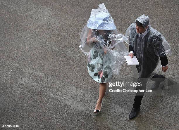 Racegoers cover themselvesfrom the rain with poncho's during Day 5 of Royal Ascot at Ascot Racecourse on June 20, 2015 in Ascot, England.