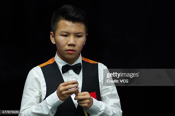 Zhou Yuelong of China B chalks his cue in quarter-finals match with Yan Bingtao of China B against Neil Robertson and Vinnie Calabrese of Australia...