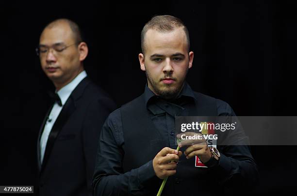 Luca Brecel of Belgium chalks his cue in quarter-finals match against Pankaj Advani of India on day six of Snooker World Cup 2015 at Wuxi Stadium on...