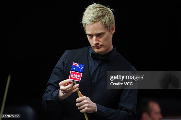 Neil Robertson of Australia chalks his cue in quarter-finals match with Vinnie Calabrese of Australia against Zhou Yuelong and Yan Bingtao of China B...