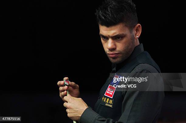 Vinnie Calabrese of Australia chalks his cue in quarter-finals match with Neil Robertson of Australia against Zhou Yuelong and Yan Bingtao of China B...