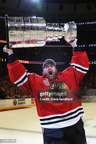 Goaltender Scott Darling of the Chicago Blackhawks hoists the Stanley Cup in celebration after his team defeated the Tampa Bay Lightning 2-0 in Game...