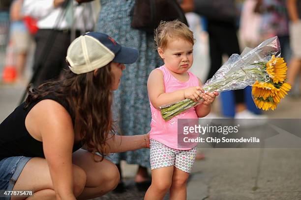 Isabelle Gudis gets a little encouragement from her mother Charlotte Gudis before placing flowers outside the historic Emanuel African Methodist...