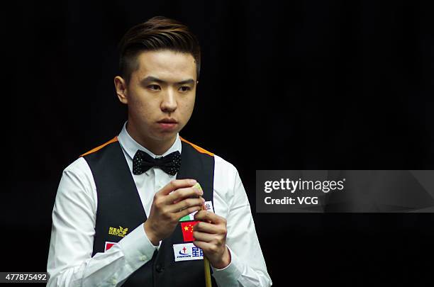 Xiao Guodong of China A chalks his cue in quarter-finals match with Ding Junhui of China A against John Higgins and Stephen Maguire of Scotland on...