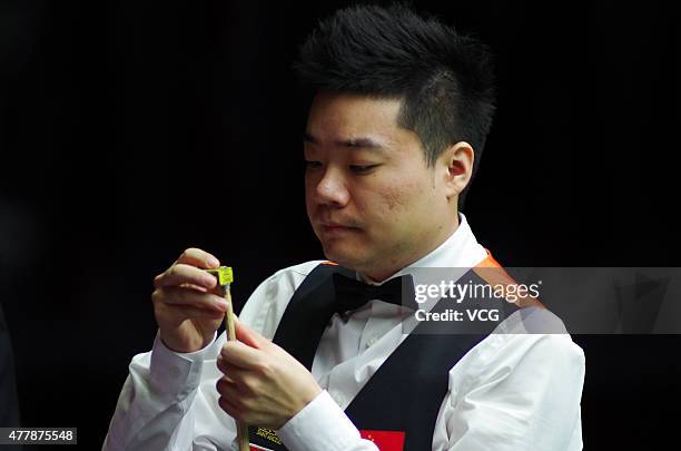 Ding Junhui of China A chalks his cue in quarter-finals match with Xiao Guodong of China A against John Higgins and Stephen Maguire of Scotland on...