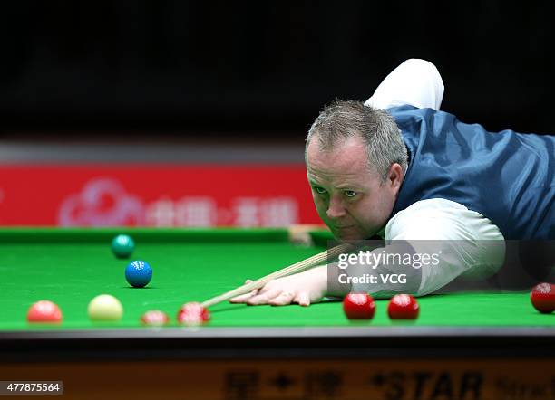 John Higgins of Scotland plays a shot in quarter-finals match with Stephen Maguire of Scotland against Ding Junhui and Xiao Guodong of China A on day...