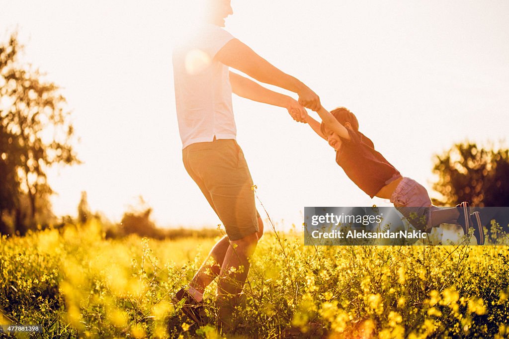 Father and baby boy having fun at the field