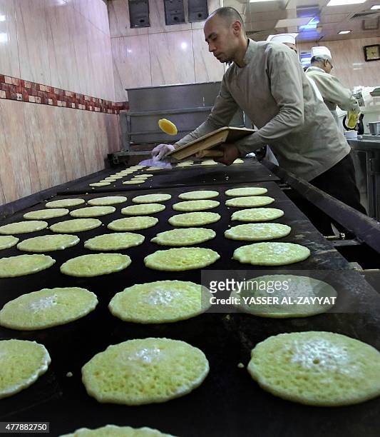 Kuwaiti employee prepares traditional Arab pancakes, known as Qatayef, at a sweets shop during the Muslim fasting month of Ramadan, on June 20 in...