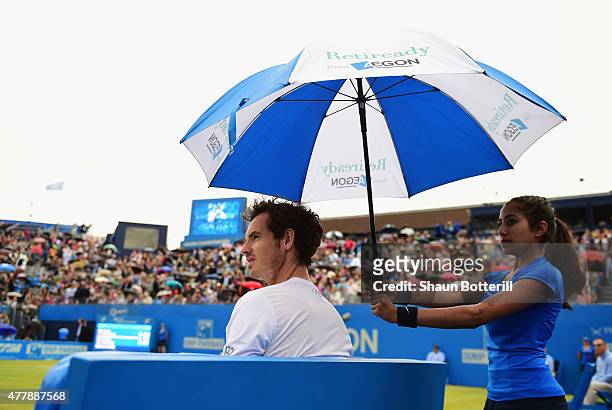Andy Murray of Great Britain shelters from the rain in his men's singles semi-final match against Viktor Troicki of Serbia during day six of the...