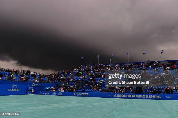 Spectators shelter from the rain as a dark rain cloud makes its way over centre court during the men's singles semi-final match between Andy Murray...