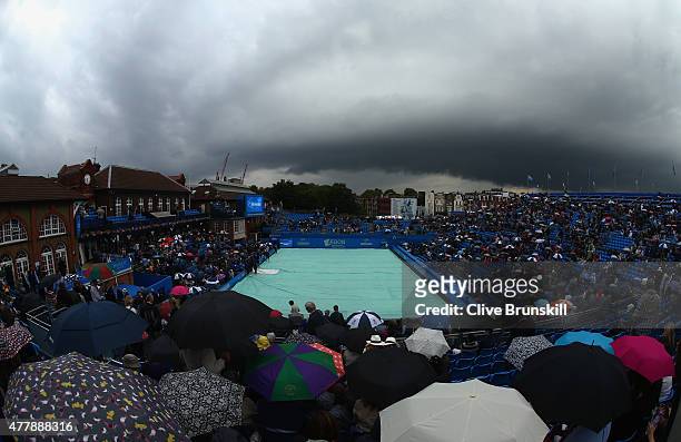 Spectators shelter from the rain as a dark rain cloud makes its way over centre court during the men's singles semi-final match between Andy Murray...