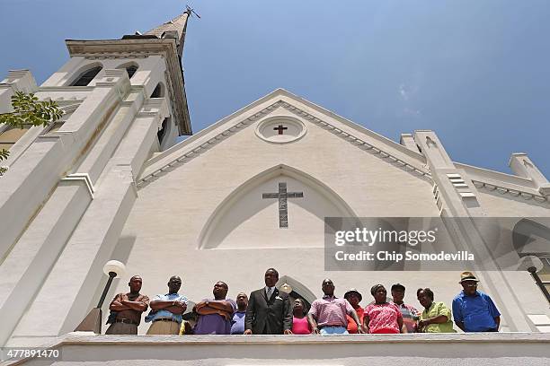 Members of the historic Emanuel African Methodist Church stand in front of the church and announce that services and Sunday school will go ahead as...