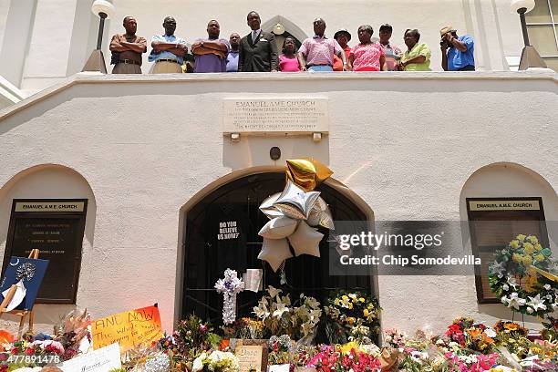 Members of the historic Emanuel African Methodist Church stand in front of the church and announce that services and Sunday school will go ahead as...