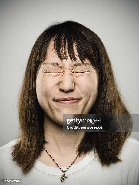 porträt eines jungen japanischen mit geschlossenen augen - pain face stock-fotos und bilder