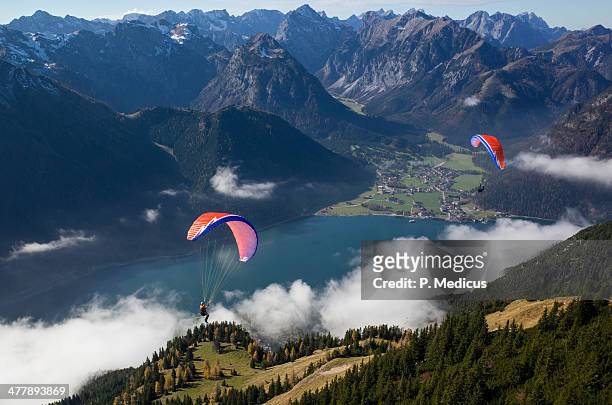 paragliding over lake achensee in rofan mountain - water glide stock pictures, royalty-free photos & images