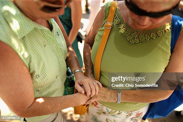 Women hold hands and pray outside the historic Emanuel African Methodist Church where nine people were shot to death earlier this week June 20, 2015...