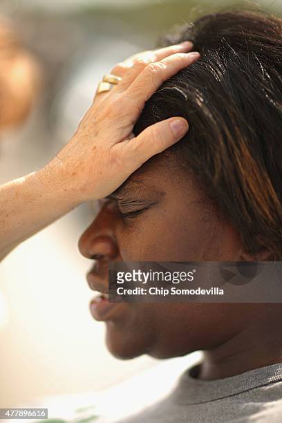 Karma Thompson prays with Linda Blankenship from the Master's Touch Ministries outside the historic Emanuel African Methodist Church where nine...