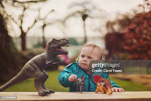 playing with dinosaur toys  in garden - dinosaur toy i stock pictures, royalty-free photos & images